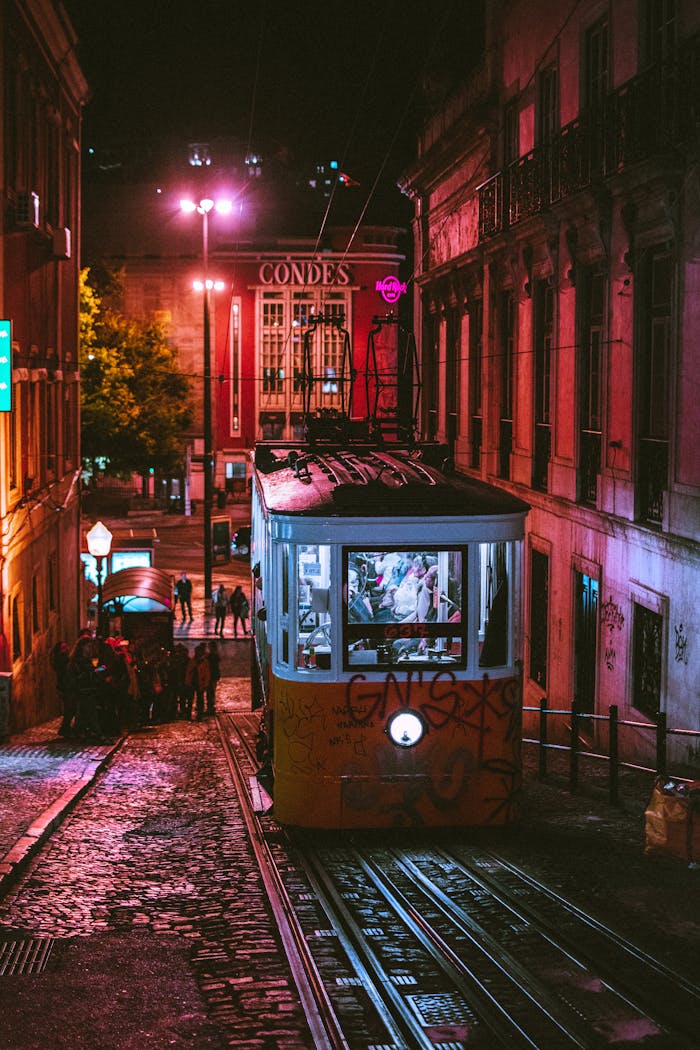 A vibrant city scene featuring a classic tram on the illuminated Lisbon streets at night.
