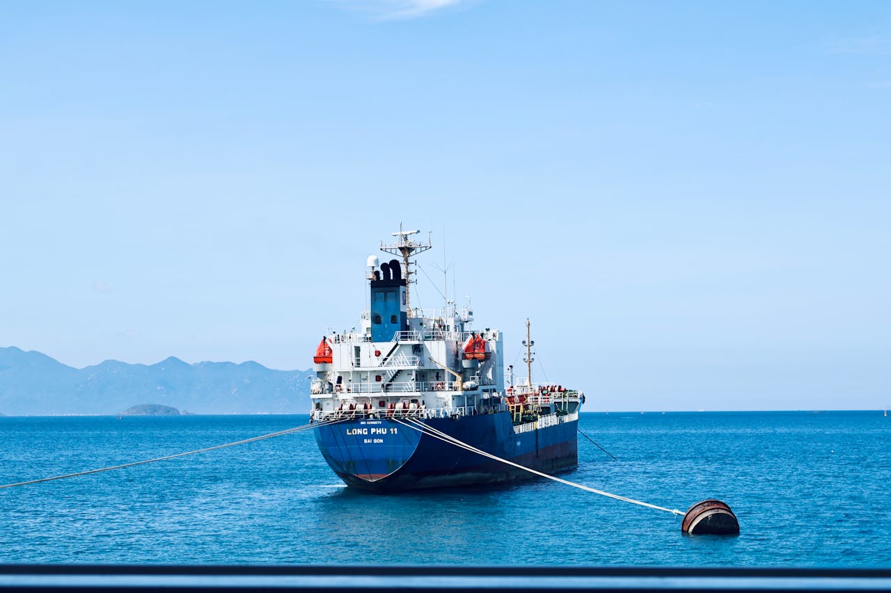 A large cargo ship moored in the clear waters of Nha Trang Bay, Vietnam.